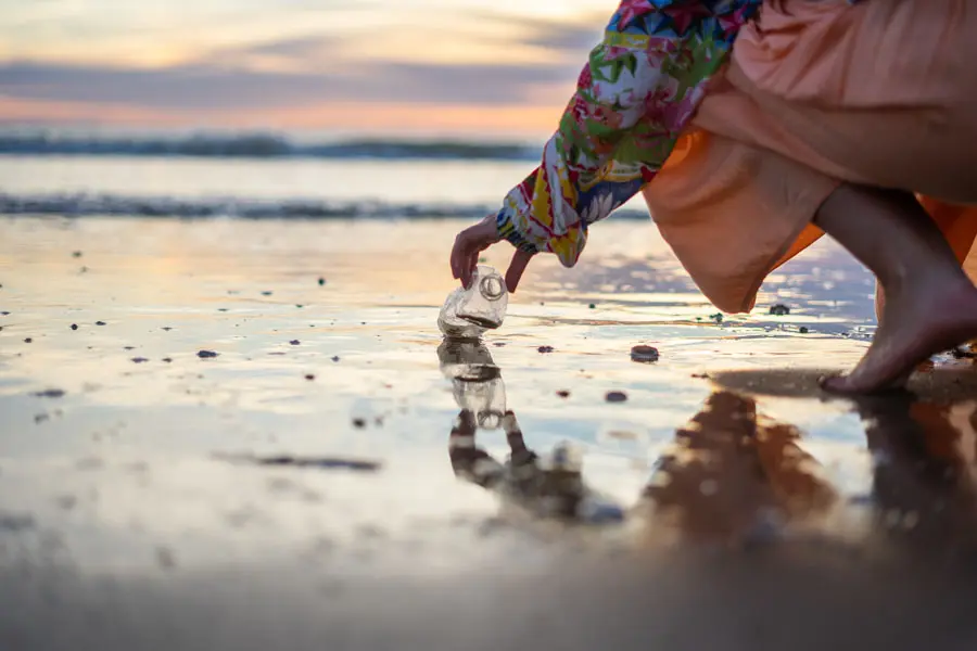 Environmental-Insurance-Woman-Picking-Up-Bottle-at-the-Beach