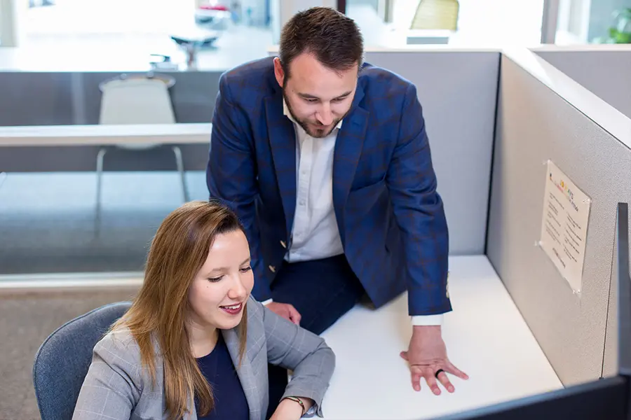 F.A.Q.'s - Two Camargo Team Memembers Working in the Office While at a Desk
