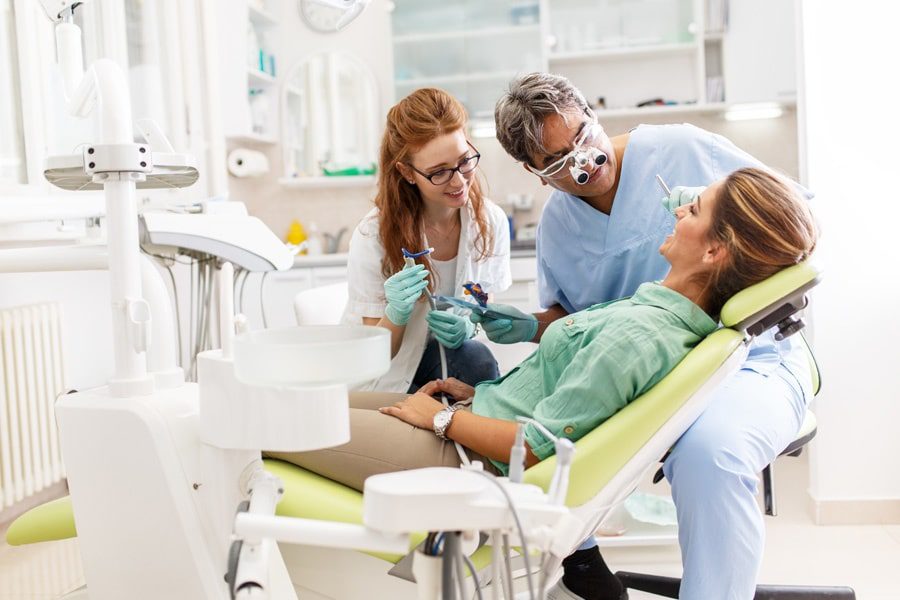 Group-Dental-Insurance-Dentist-and-Dental-Assistant-Performing-a-Cleaning-min